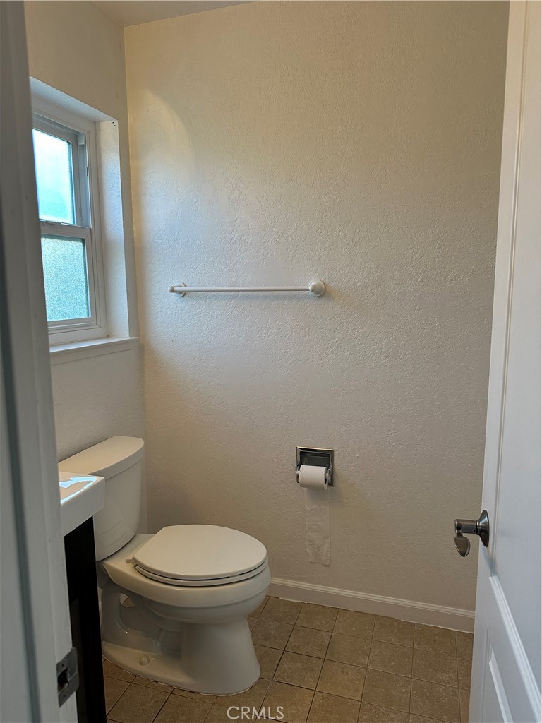 16768 Buckeye Circle Fountain Valley, CA 92708 - Photo 11 of 17 a white toilet sitting next to a bathroom sink and vanity