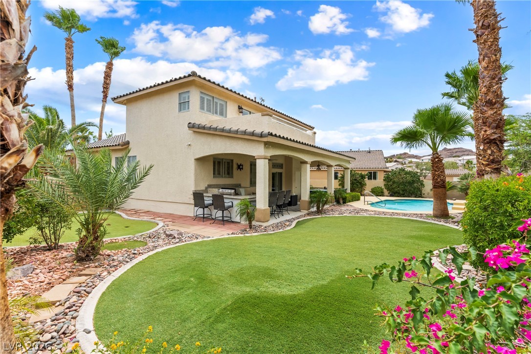 708 Vortex Avenue Henderson, NV 89002 - Photo 2 of 71 Lush landscaping and a refreshing pool define this desert oasis, perfect for relaxation and entertainment.
