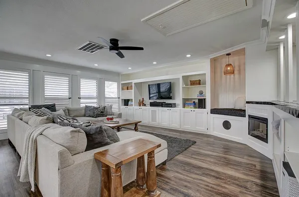 a living room with furniture a flat screen tv and a table