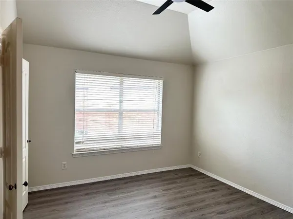 an empty room with a window and a ceiling fan