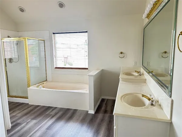 a bathroom with a tub sink and mirror