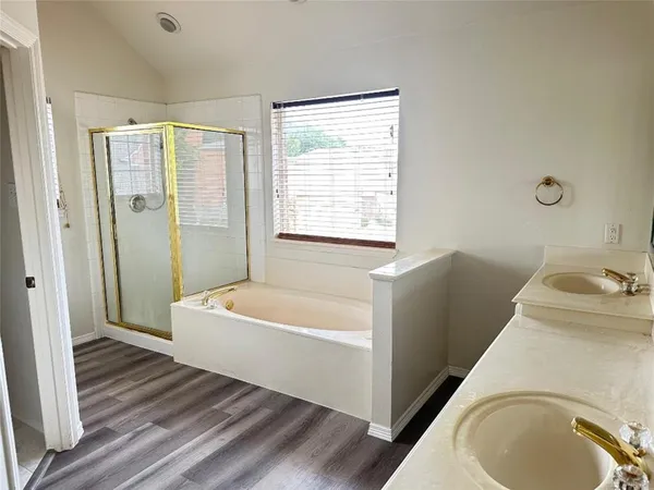 a bathroom with a tub a sink and a window