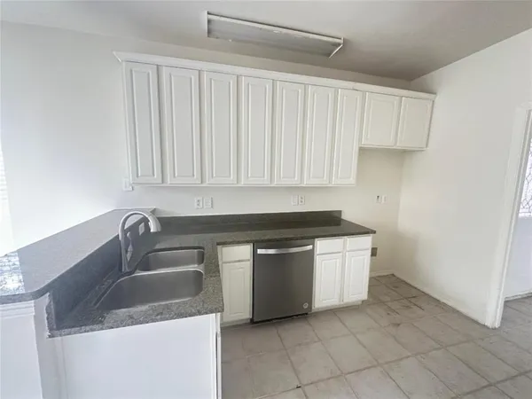 a kitchen with stainless steel appliances granite countertop a sink and a white cabinets