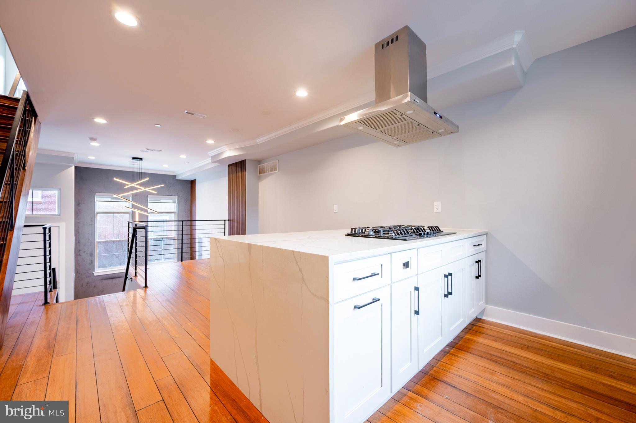 605 McClellan Street Philadelphia, PA 19148 - Photo 22 of 26 a kitchen with stainless steel appliances kitchen island wooden floors granite counter tops and a view of living room
