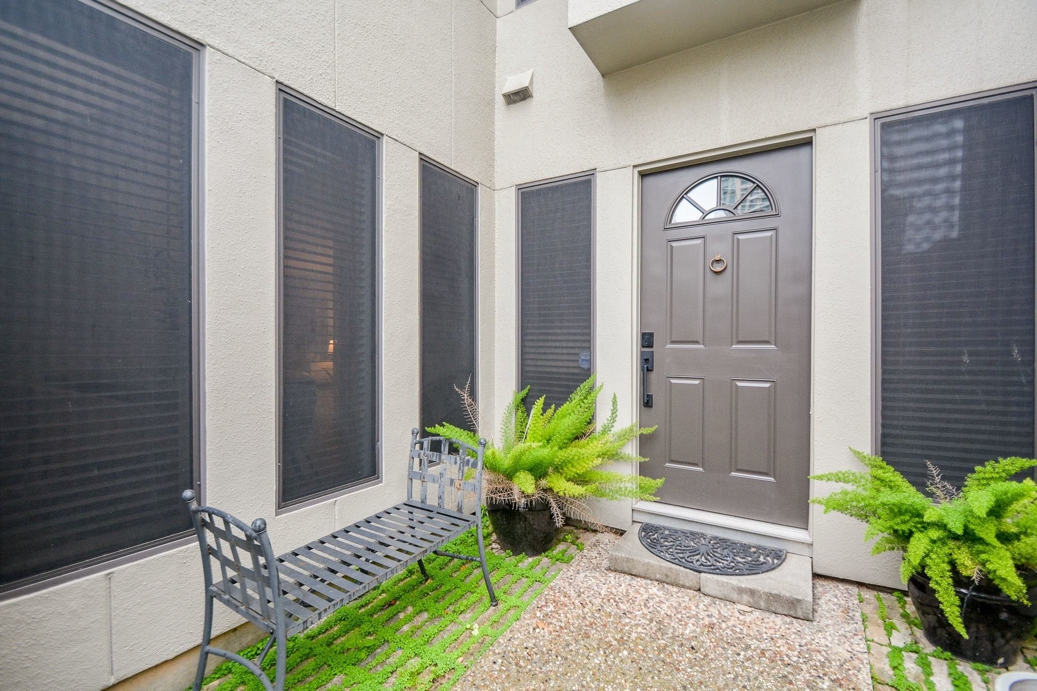 820 Harold Street Houston, TX 77006 - Photo 2 of 33 The front entry offers a welcoming, garden-style arrival with a classic dark door and manicured greenery on all sides.