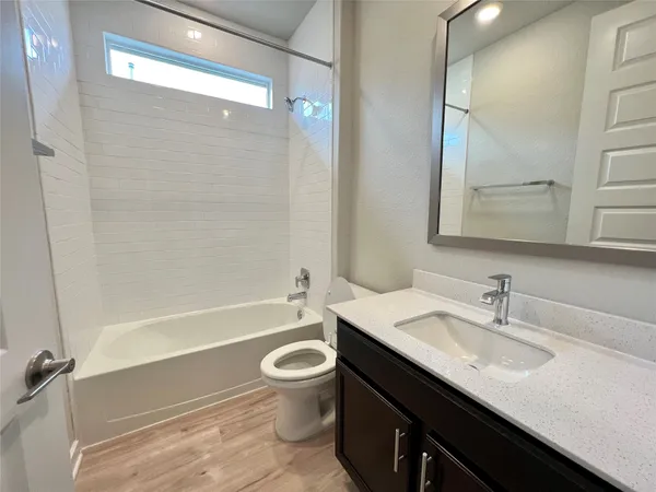 a bathroom with a sink a toilet a mirror and shower