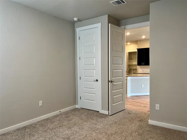 an empty room with a bathroom and mirror