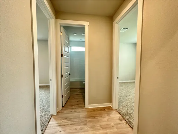 a view of hallway with wooden floor
