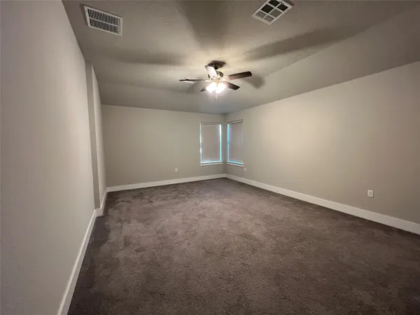 en empty room with windows and fan