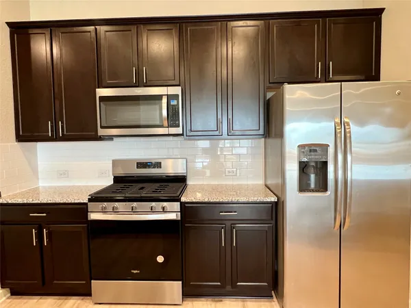a kitchen with granite countertop stainless steel appliances and wooden cabinets