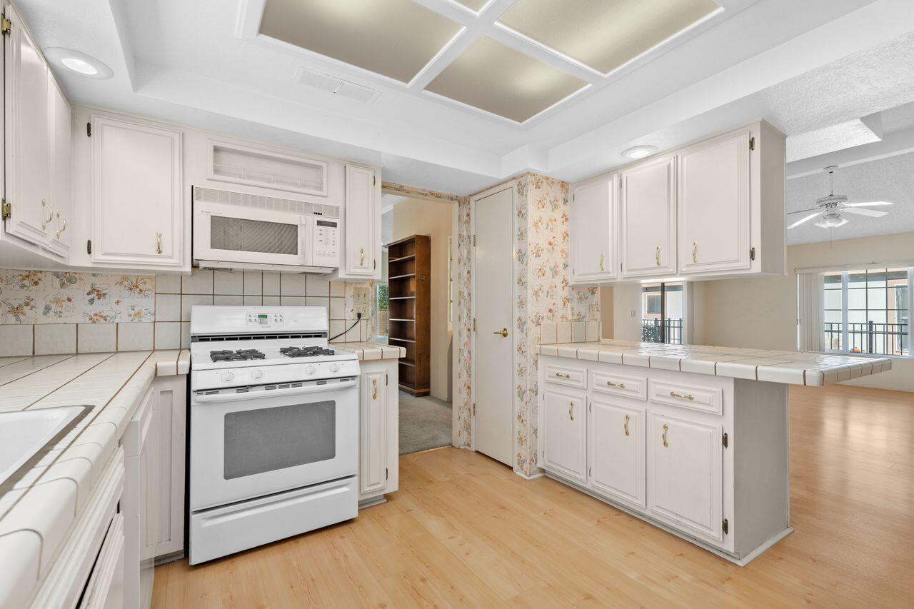 47857 Prado Way Indio, CA 92201 - Photo 15 of 36 a kitchen with granite countertop white cabinets and white appliances