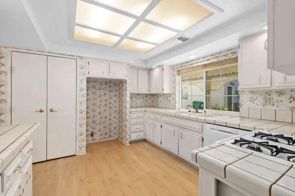 a kitchen with white cabinets and white appliances