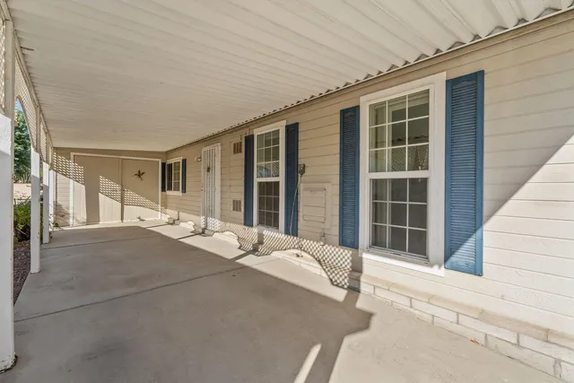 a balcony with a bed and a large window