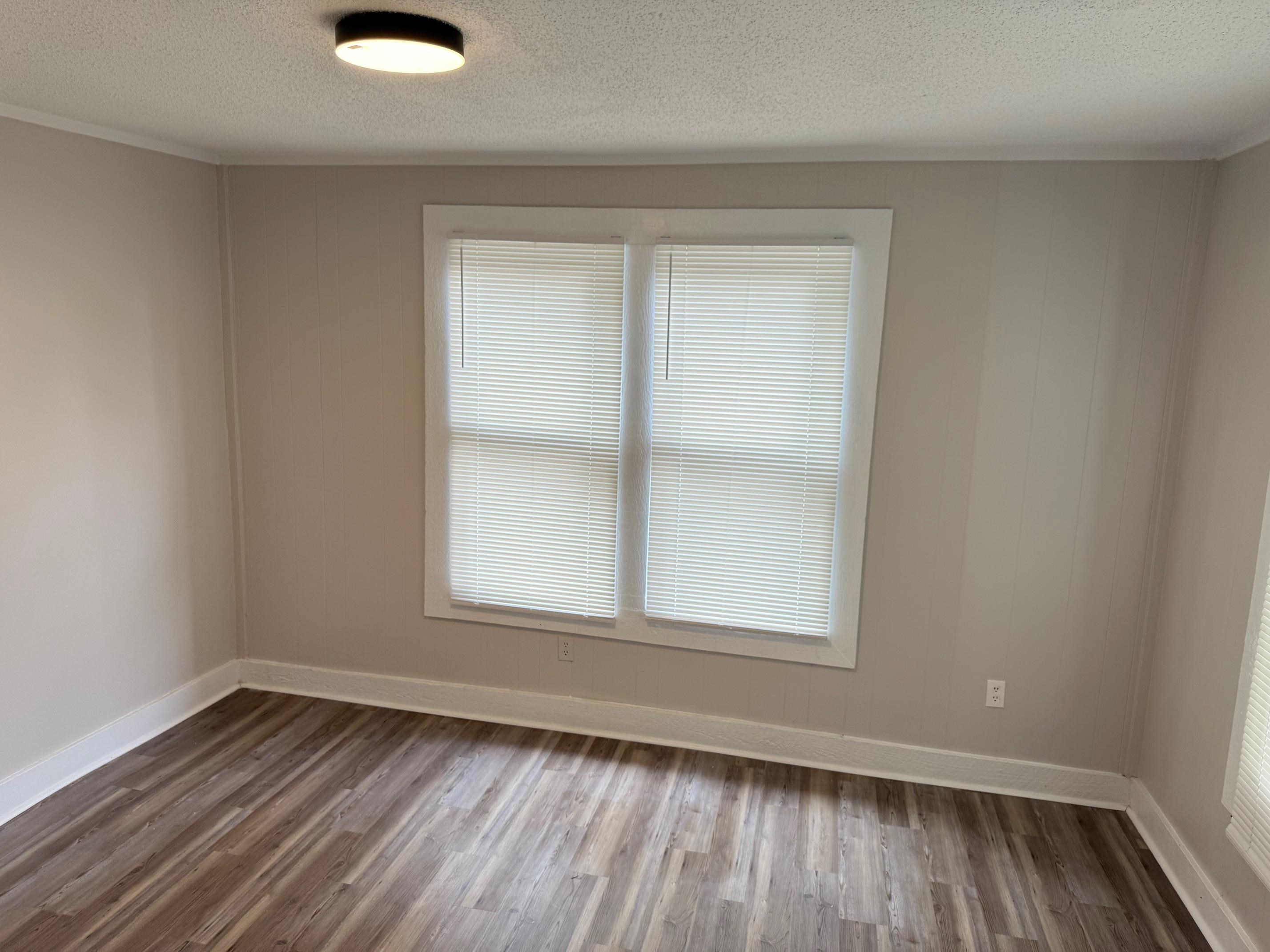 5657 Raleigh Lagrange Road Memphis, TN 38134 - Photo 2 of 8 Empty room with dark wood finished floors, a textured ceiling, and baseboards