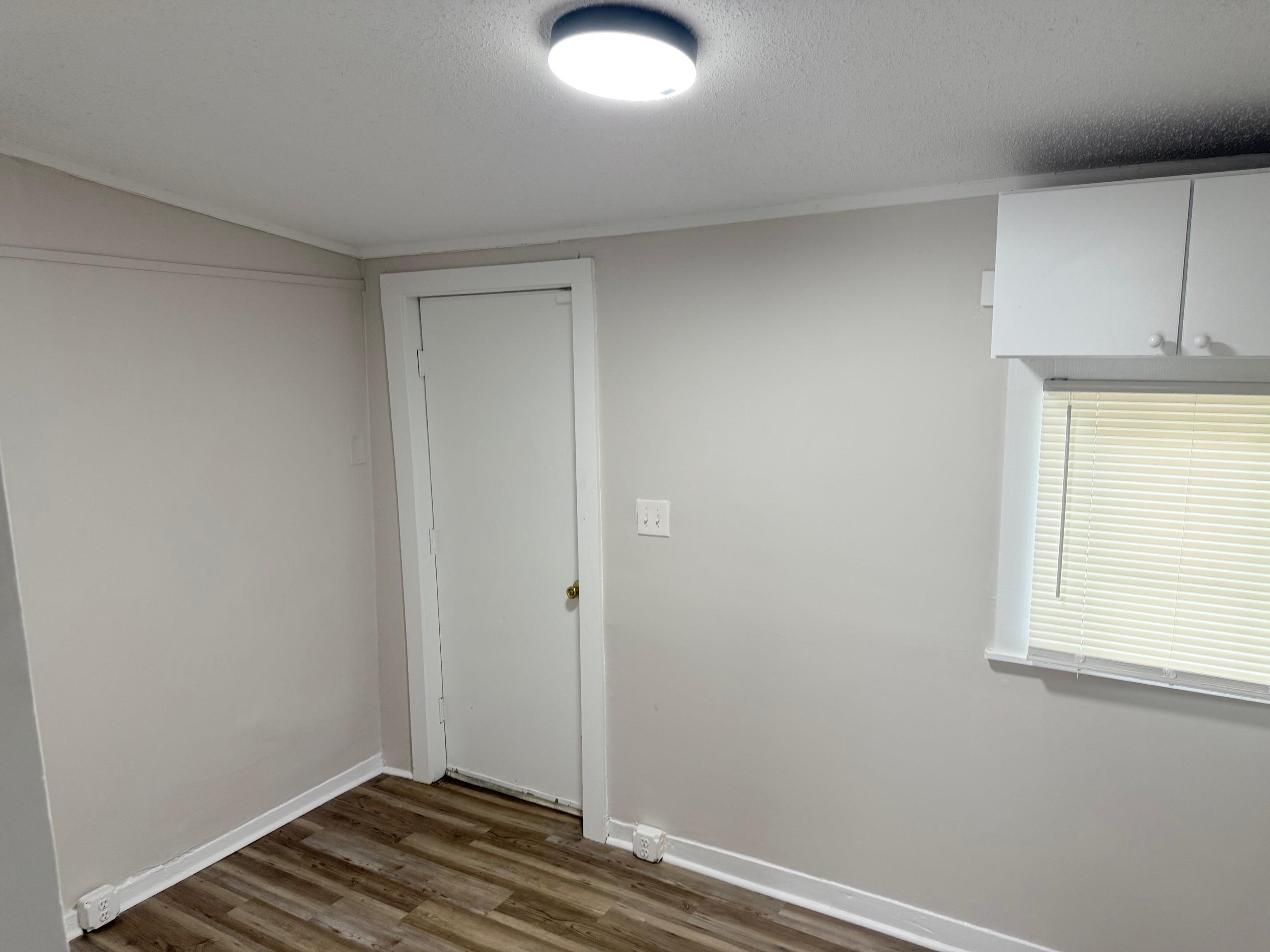 5657 Raleigh Lagrange Road Memphis, TN 38134 - Photo 5 of 8 Unfurnished room featuring dark wood-type flooring, baseboards, and a textured ceiling