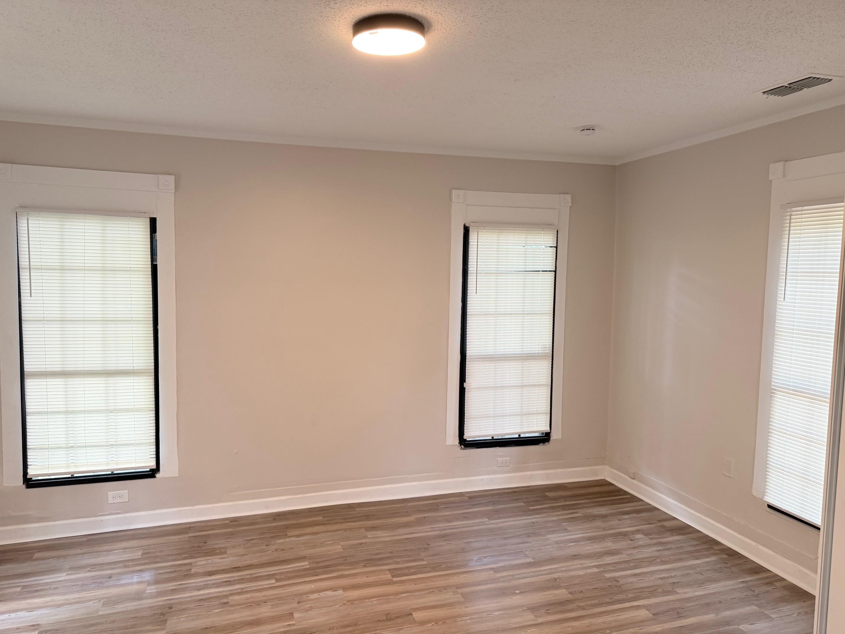 5657 Raleigh Lagrange Road Memphis, TN 38134 - Photo 7 of 8 Empty room featuring light wood-style floors, a textured ceiling, crown molding, and baseboards