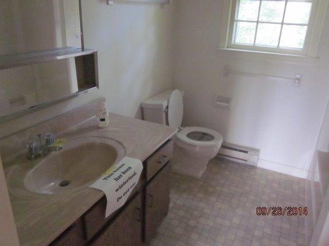 110 West Main Street, Unit 15 Hyannis, MA 02601 - Photo 3 of 10 a bathroom with a toilet sink and mirror