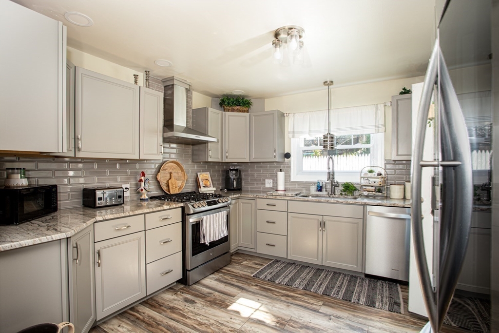 425 Pearce Street Fall River, MA 02720 - Photo 18 of 33 a kitchen with stainless steel appliances granite countertop a sink a stove a refrigerator cabinets and a window
