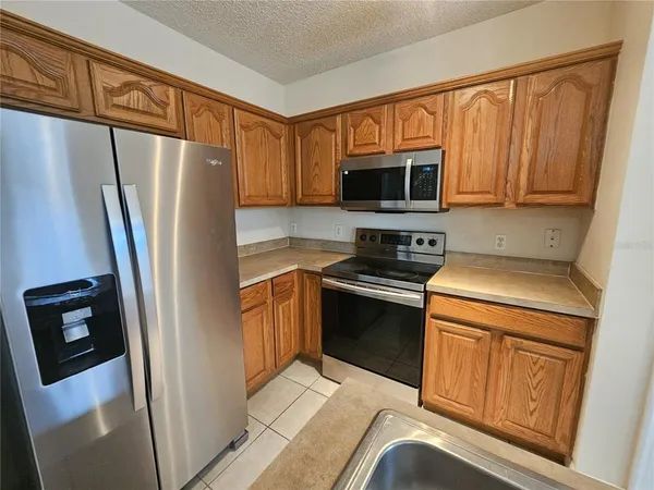 a kitchen with stainless steel appliances granite countertop a refrigerator a stove top oven a sink and dishwasher