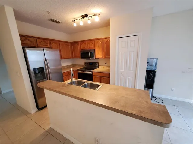 a living room with stainless steel appliances furniture a fireplace and a flat screen tv