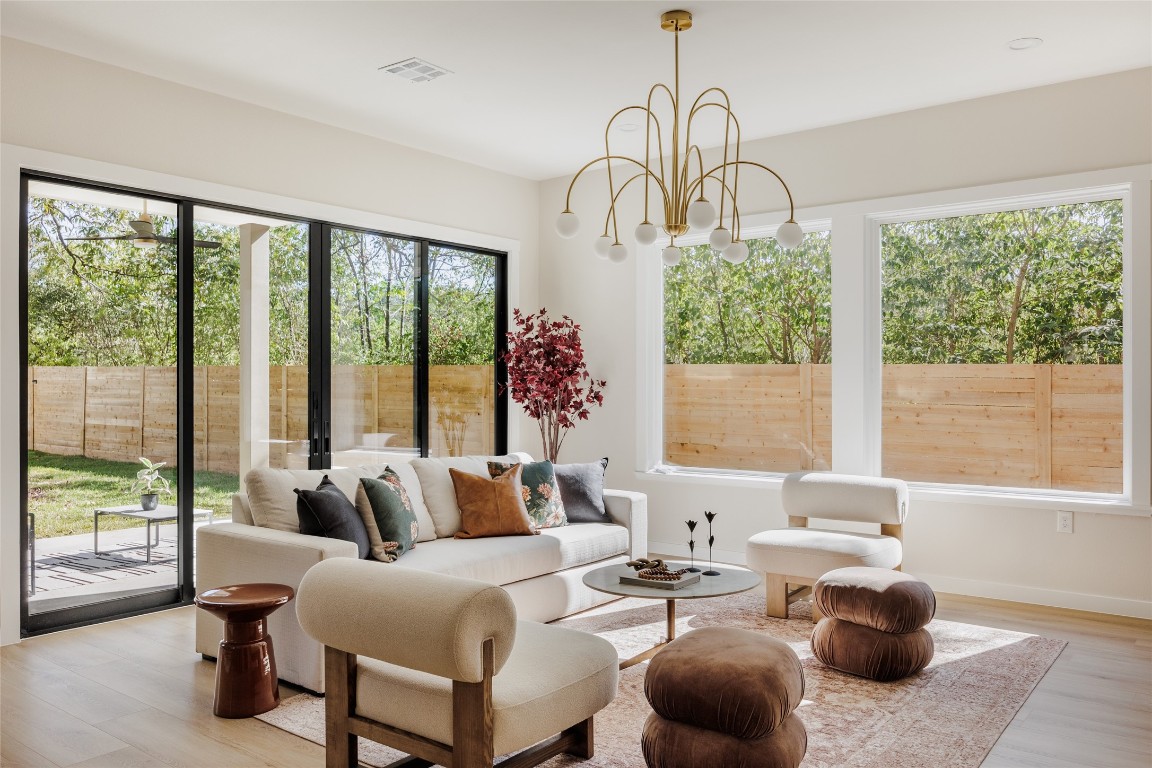 Sunroom featuring plenty of natural light and a chandelier
