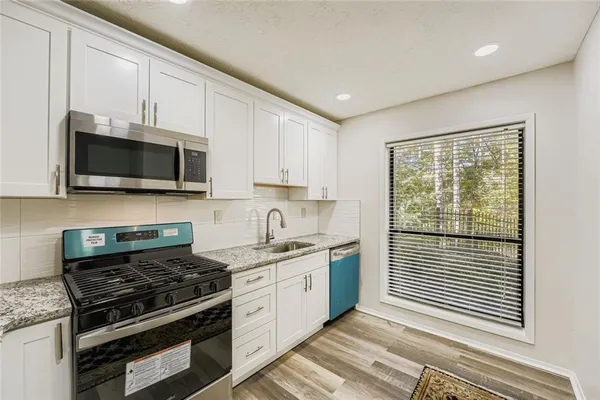 a kitchen with a stove a sink and a microwave