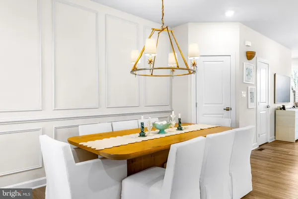a large white kitchen with stainless steel appliances lots of counter space and wooden floor