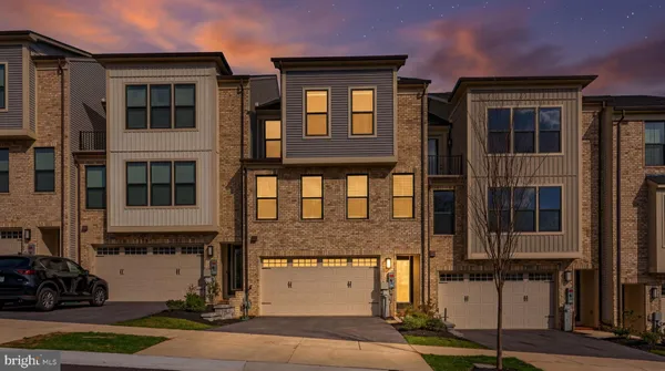 a front view of a building with a garden and plants