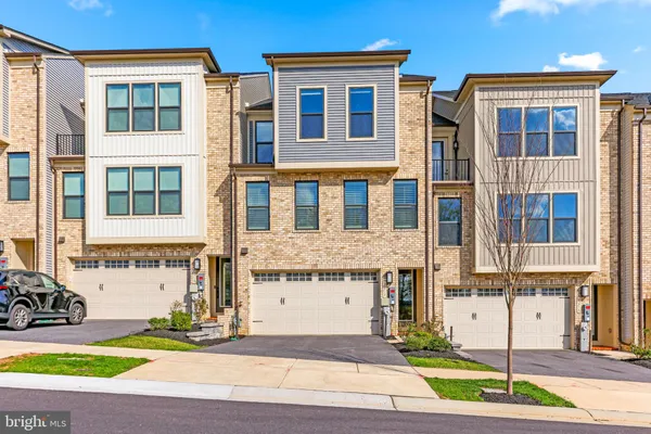 a view of an empty room with wooden floor and stairs