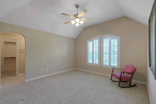 an aerial view of a house with swimming pool and large trees
