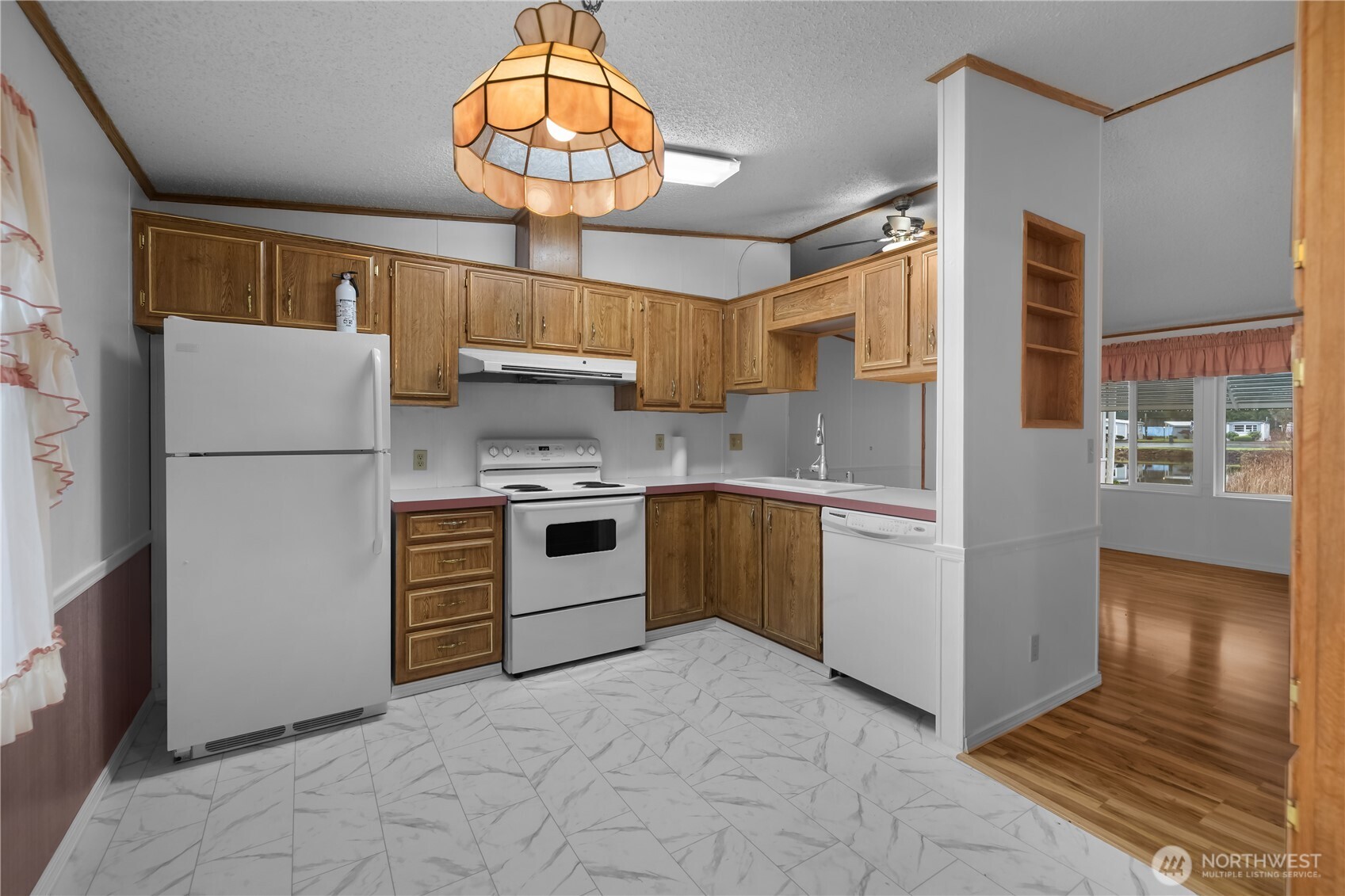 930 Trosper Road Southwest, Unit 78 Tumwater, WA 98512 - Photo 13 of 36 a kitchen with a refrigerator a stove and a wooden floor