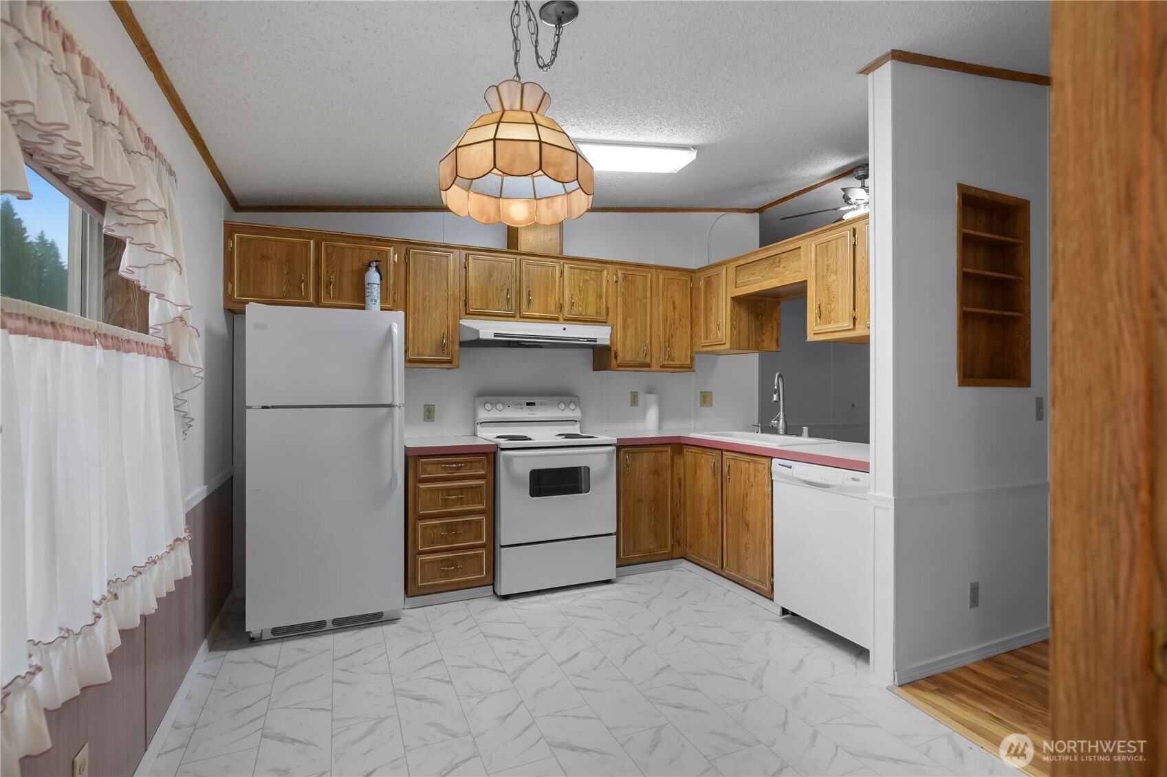 930 Trosper Road Southwest, Unit 78 Tumwater, WA 98512 - Photo 15 of 36 a kitchen with a refrigerator a stove cabinets and living room view