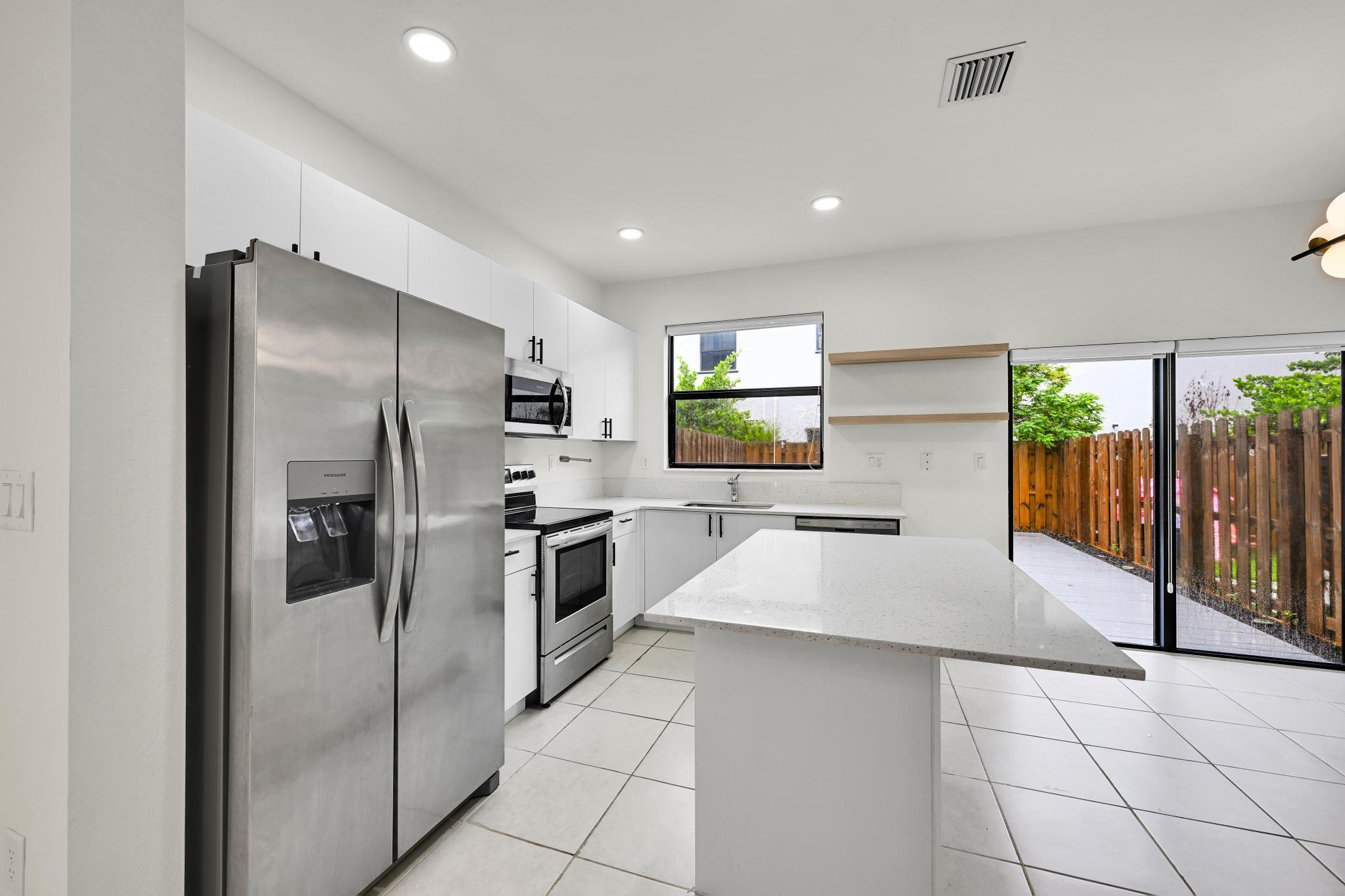 13234 Southwest 285th Street Homestead, FL 33033 - Photo 7 of 49 a large kitchen with stainless steel appliances a refrigerator and a stove top oven