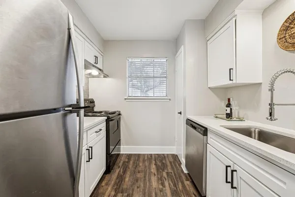 a kitchen with a sink a refrigerator and cabinets