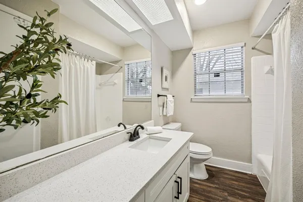 a bathroom with a sink toilet and window