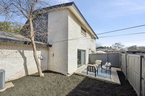 a view of a chair and table in backyard of the house