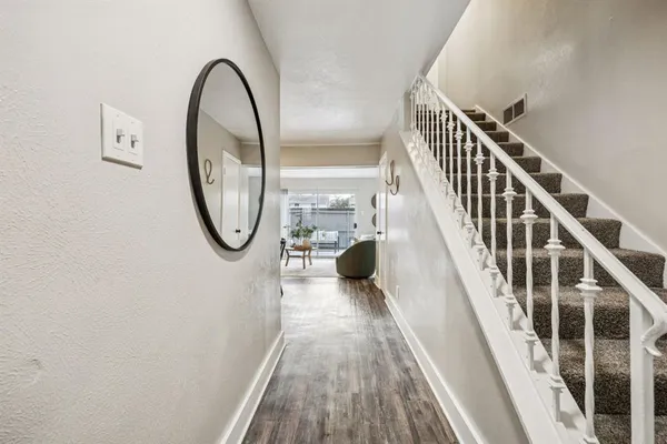 a view of a hallway with wooden floor and staircase
