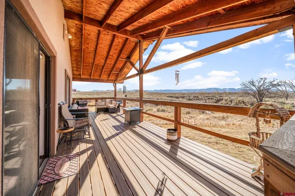 a view of a balcony with furniture and wooden floor