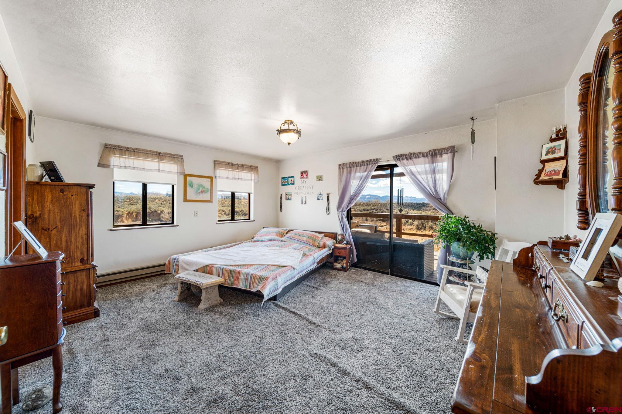 25220 County Rd M Cortez, CO 81321 - Photo 33 of 45 a bedroom with bed and glass door