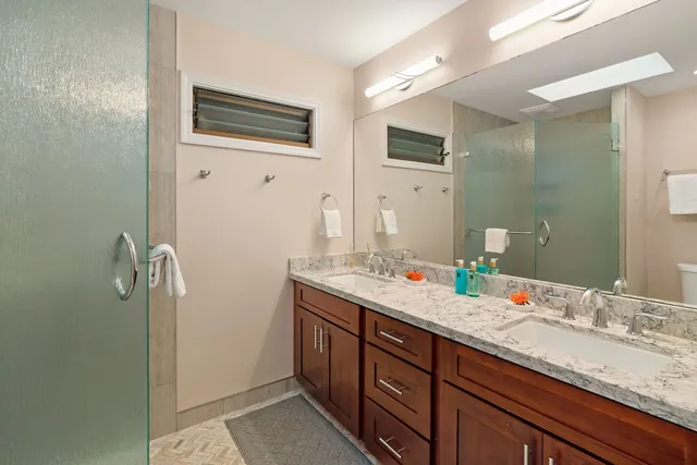 a bathroom with double sink and a mirror