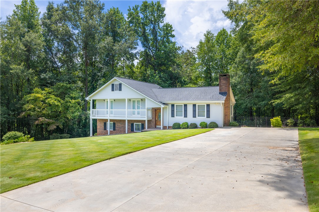 404 South Old Mill Road Seneca, SC 29678 - Photo 36 of 39 Mature trees frame a classic exterior accented by a brick chimney and expansive driveway.