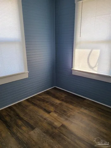 a view of a small space with wooden floor and a window