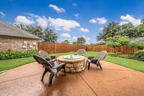 a backyard of a house with table and chairs