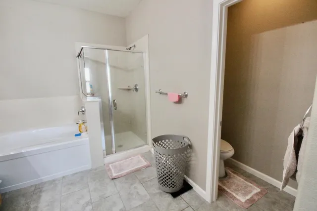 a bathroom with a granite countertop shower and a tub