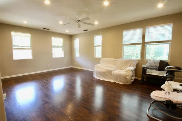 a spacious bedroom with a bed and wooden floor
