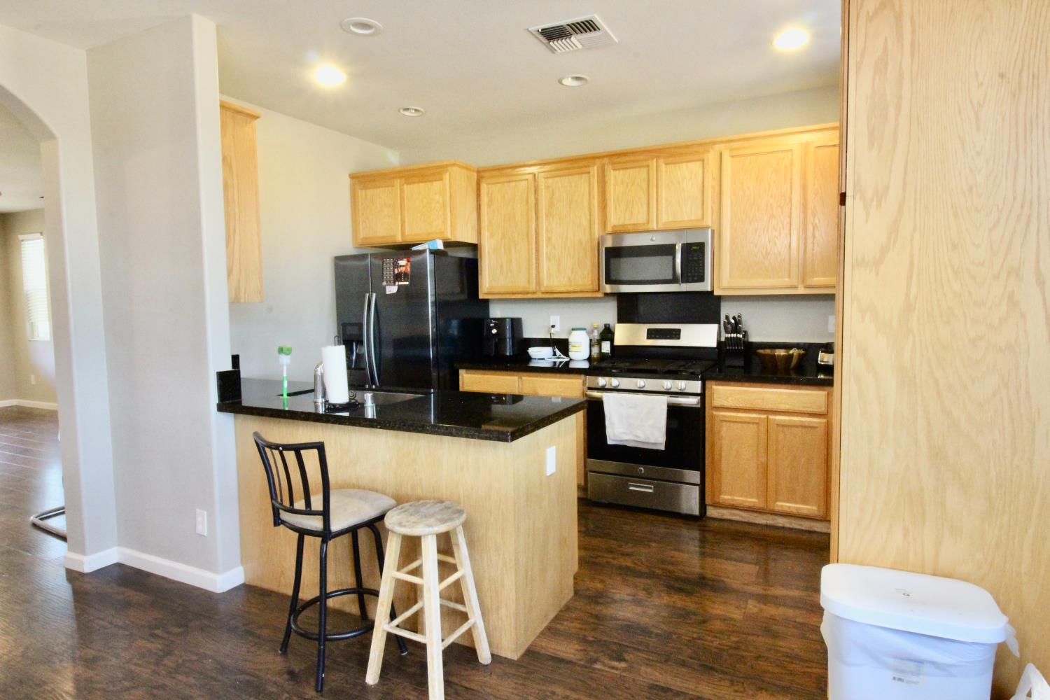 706 Annemarie Way Isleton, CA 95641 - Photo 7 of 21 a kitchen with stainless steel appliances granite countertop a stove top oven a sink dishwasher a dining table and chairs with wooden floor