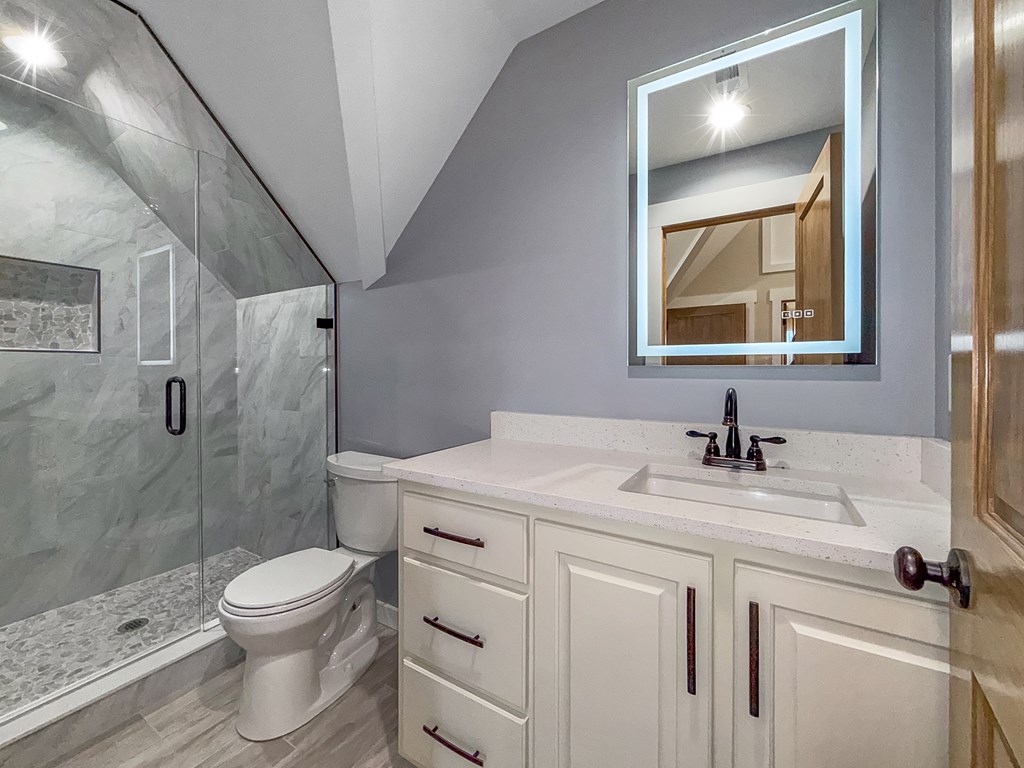 105 West Riveredge Drive Ellijay, GA 30536 - Photo 44 of 56 a bathroom with a granite countertop sink toilet a mirror and shower