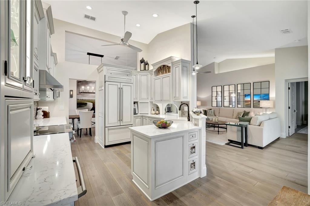 2540 Talon Court, Unit 504 Naples, FL 34105 - Photo 31 of 31 Kitchen featuring paneled fridge, open floor plan, light stone counters, a peninsula, and hanging light fixtures