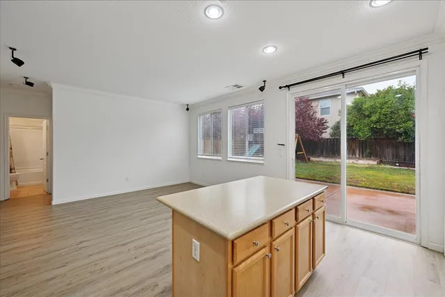 an open kitchen with wooden floor and large window