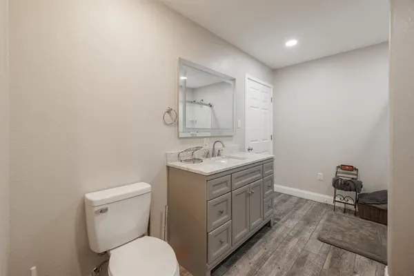 a bathroom with a toilet a sink and mirror